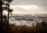 Osiedla Gdyni widziane ze wzgórza: bloki, kamienice i nowe zabudowania, w oddali morze