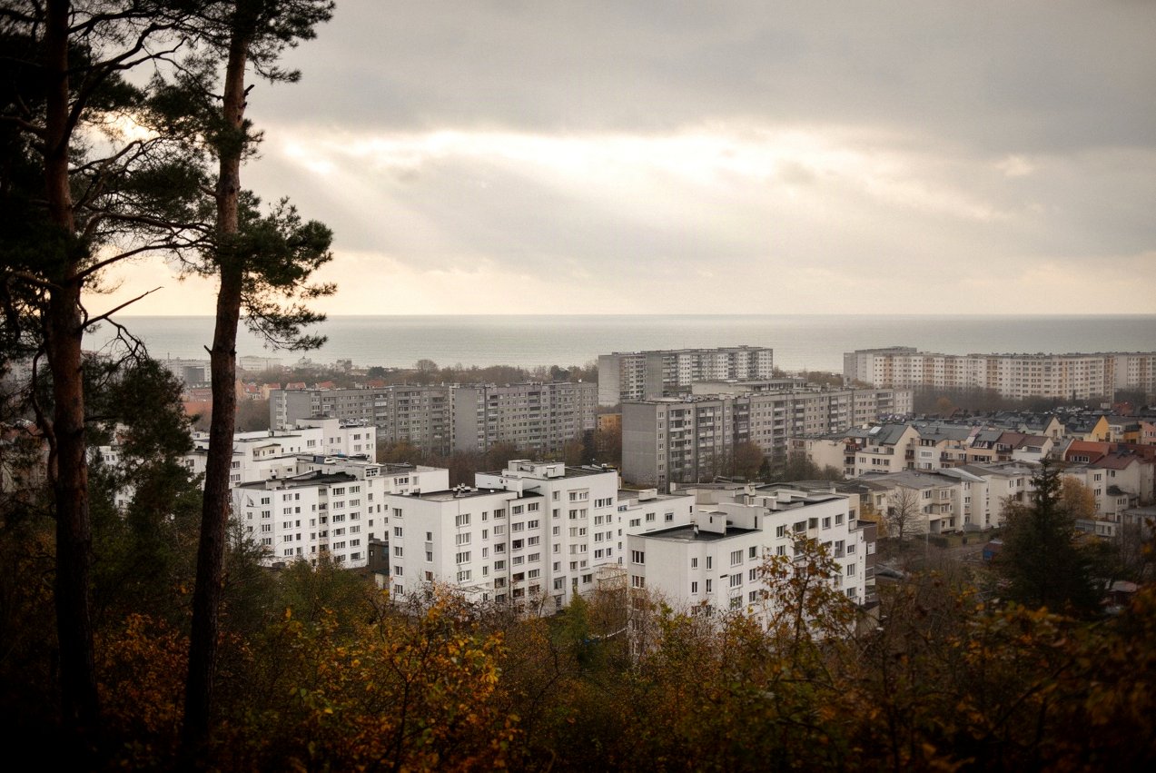 Osiedla Gdyni widziane ze wzgórza: bloki, kamienice i nowe zabudowania, w oddali morze